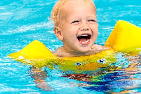 Toddler with swim floaties in pool
