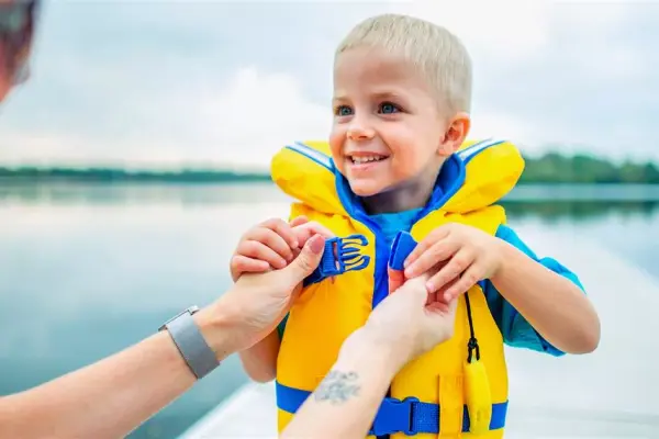 Child wearing life jacket at lake